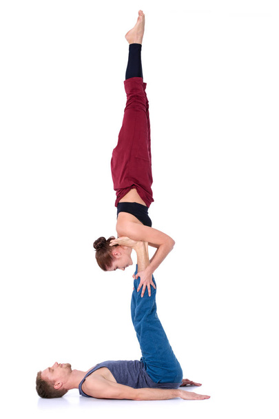 Young athletic couple practicing acroyoga. Balancing in pair - Fotografie, Obrázek