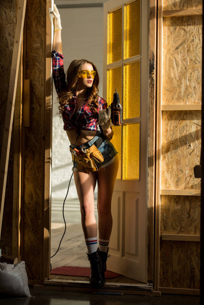 szexi lány pózol az elektromos fúró építési - Fotó, kép