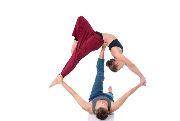 Young athletic couple practicing acroyoga. Balancing in pair - Photo, Image