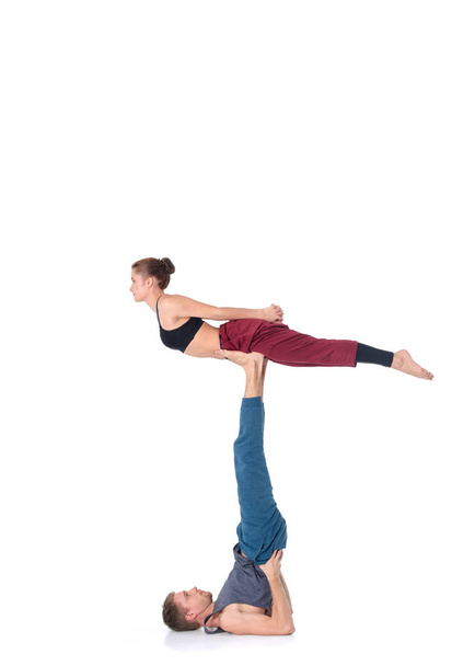 Young athletic couple practicing acroyoga. Balancing in pair - Valokuva, kuva