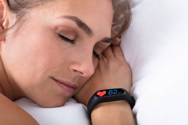 Fitness Activity Tracker With Heartbeat Rate On Woman Hand Over Bed - Photo, Image