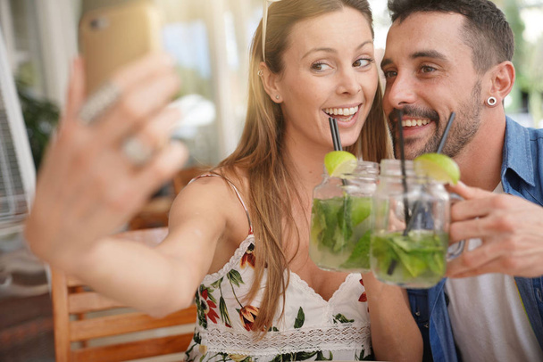 Couple taking selfie pictures while drinking mojitos - Foto, Bild
