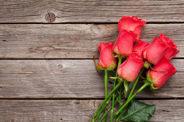Valentijnsdag wenskaart met rode rozen op de houten tafel. Bovenaanzicht met ruimte voor tekst - Foto, afbeelding