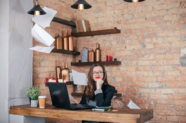 Young freelancer girl is working hard in laptop in loft interior - Photo, image