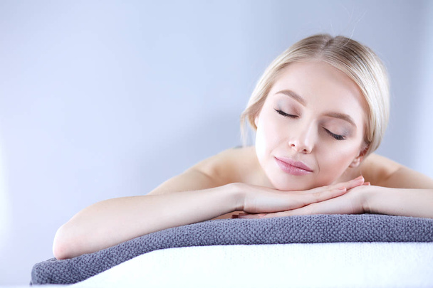 Young woman lying on a massage table,relaxing with eyes closed. Woman. Spa salon - Foto, afbeelding