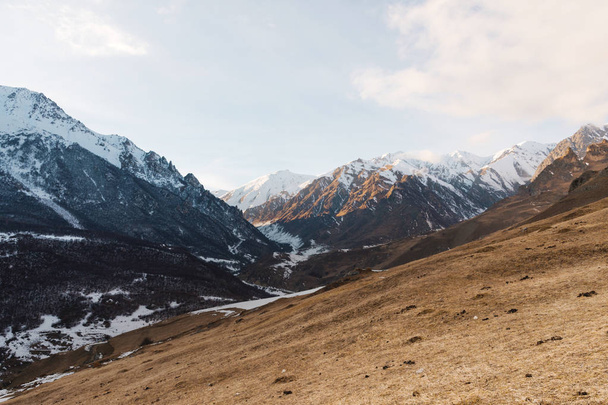 Caucasian mountains. Rock Likoran in Upper Balkaria in the clouds. Winter landscape of bald mountains. - Фото, зображення