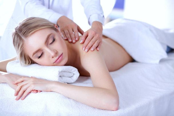 Young woman lying on a massage table,relaxing with eyes closed. Woman. Spa salon - Foto, immagini