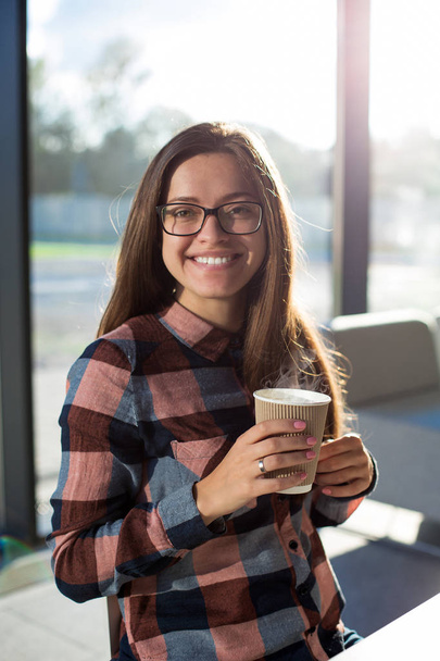 Young female girl student having coffee break in glass interior - Zdjęcie, obraz