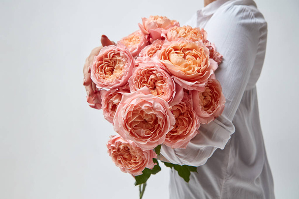 cropped photo of woman holding bouquet of pink roses - Фото, изображение