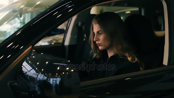 Brunette Woman in Luxury Car salon holding hands on steering wheel - Footage, Video