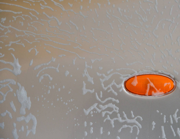 Пена для мытья автомобиля вручную на автомобильной поверхности
 - Фото, изображение