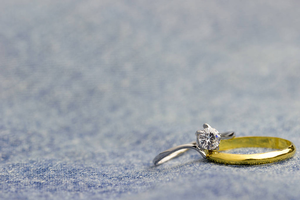 Fałszywe pierścionek z brylantem i złoty pierścień umieszczony na Jean jecket. Koncepcja miłości i małżeństwa. Miejsce można pisać artykuły o Walentynki. - Zdjęcie, obraz