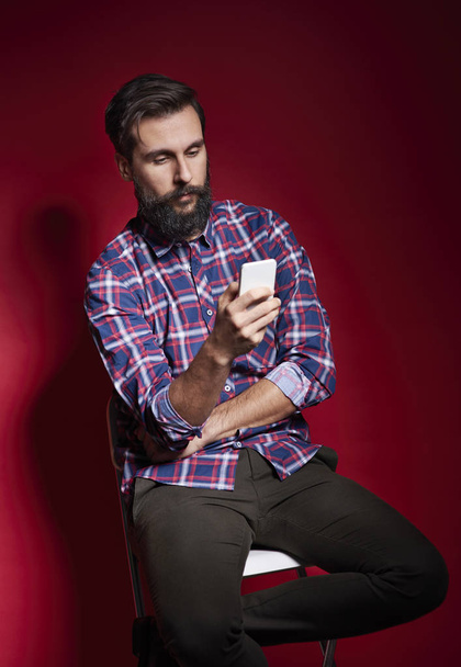 Man sitting on chair and using mobile phone  - Photo, Image