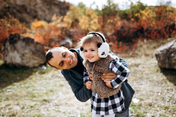 Pai segurando filha menor nas mãos e sorrindo
 - Foto, Imagem