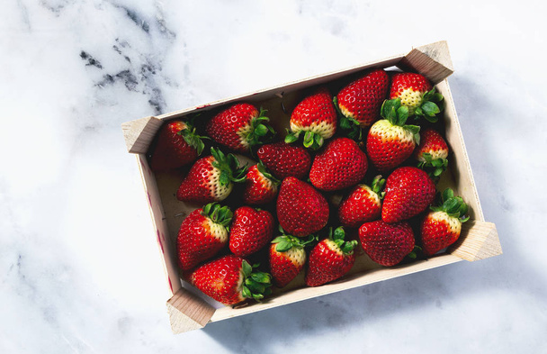 Pile of juicy ripe organic strawberries in a wooden box. sale on - Foto, afbeelding