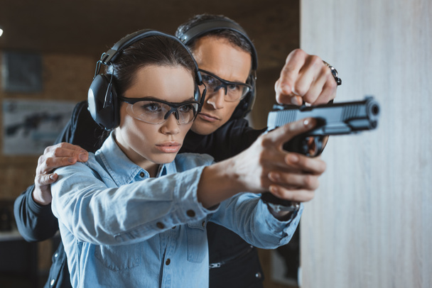 instructor helping customer in shooting gallery - Photo, Image