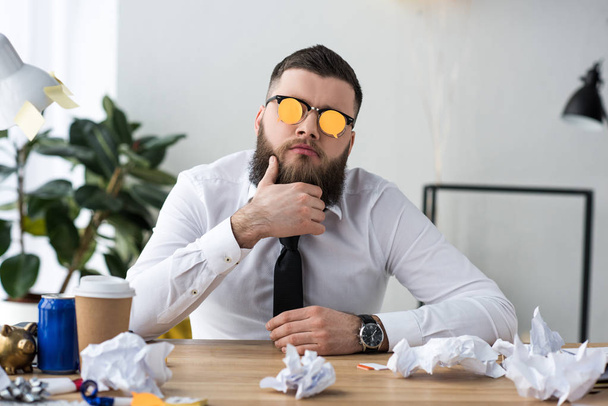 retrato de hombre de negocios con notas adhesivas en las gafas en el lugar de trabajo en la oficina
 - Foto, Imagen