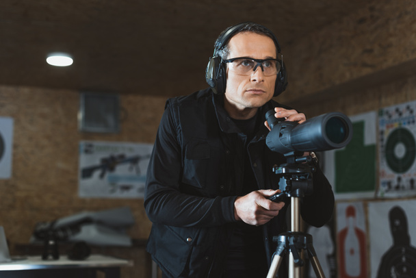 man fixing binoculars in shooting range - Fotografie, Obrázek