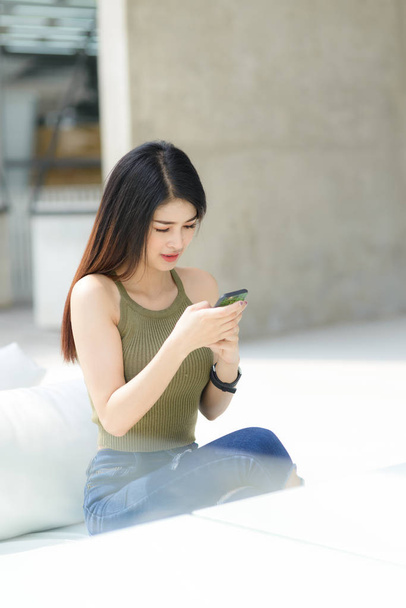 Beautiful Asian woman using smartphone with building background, - Foto, imagen