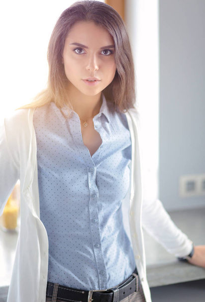 Young woman is standing near window. Business Woman. - Foto, afbeelding