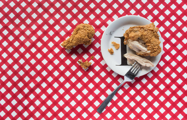 Panier de poulet frit avec assiette sur nappe damier rouge
 - Photo, image