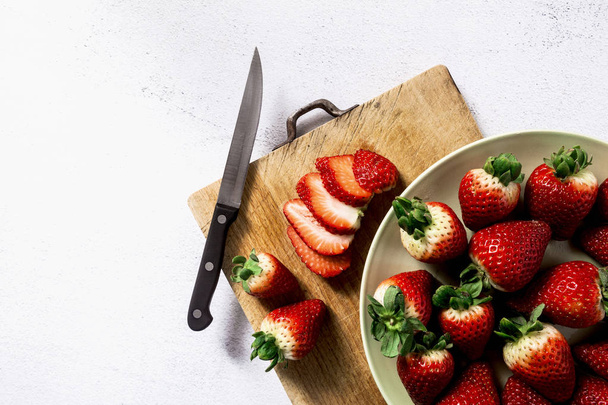 a pile of fresh juicy ripe strawberries on a cutting board and a - Φωτογραφία, εικόνα