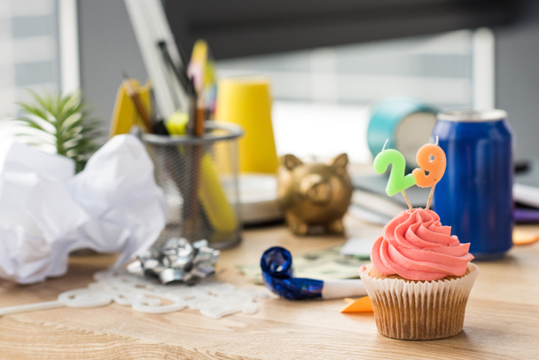selective focus of birthday cupcake and party decorations at workplace - Fotó, kép