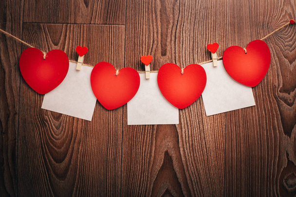 Love Valentine's hearts and card natural cord and red clips hanging on rustic driftwood texture background, copy space - 写真・画像