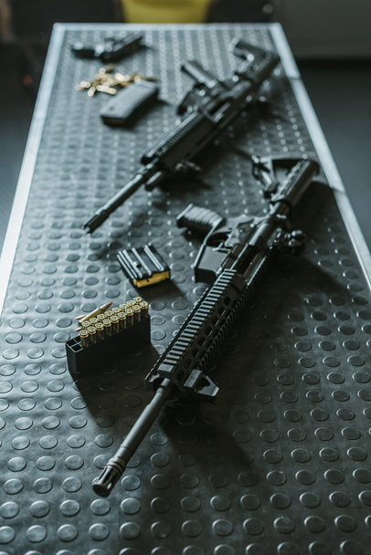 high angle view of rifles with bullets on table in shooting range - Fotoğraf, Görsel