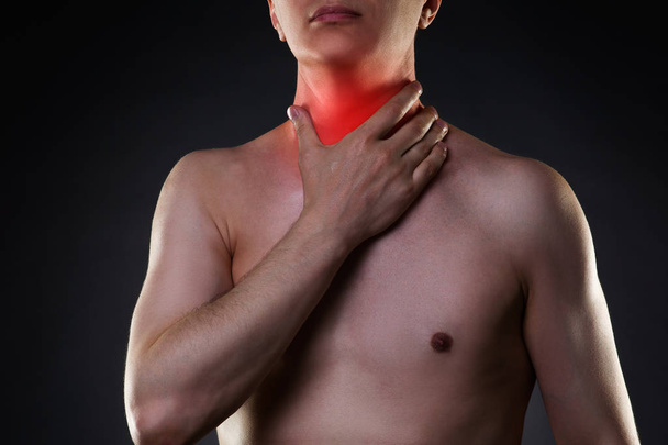 Sore throat, men with pain in neck, black background - Foto, Bild