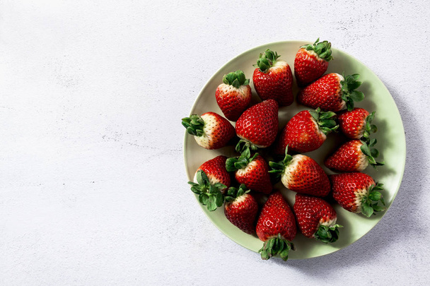 a pile of fresh juicy ripe strawberries on the plate - Φωτογραφία, εικόνα