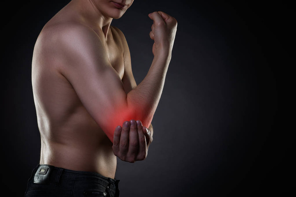Pain in elbow, joint inflammation with red dot on black background - Фото, изображение