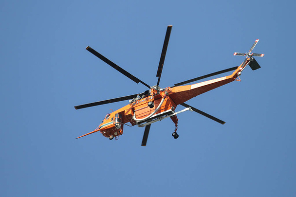 Helicóptero Naranja Fuego está volando sobre la ciudad
 - Foto, Imagen