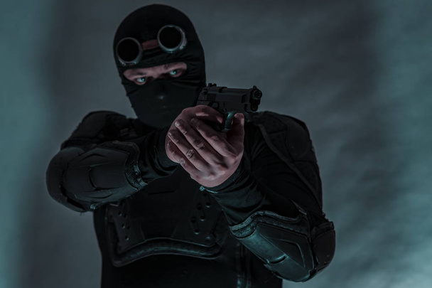 Armed spy in bulletproof vest. The gun is aimed at the target. - Foto, Bild
