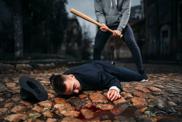 ladrón matando víctima con bate de béisbol en la calle de noche, concepto de crimen
 - Foto, Imagen