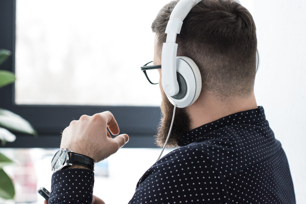 częściowy widok człowieka z smartphone słuchania muzyki w słuchawkach - Zdjęcie, obraz
