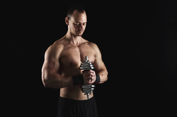 Strong athletic man with dumbbell showes naked muscular body - Foto, Imagem