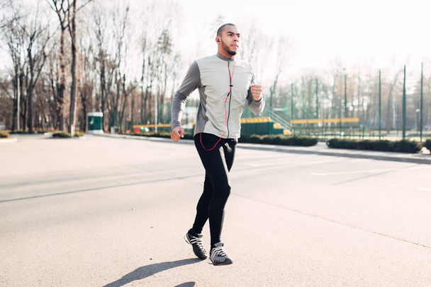 Běžec s sluchátka v parku, rychlost běží, zdravého životního stylu. Atlet na ranní fitness cvičení - Fotografie, Obrázek