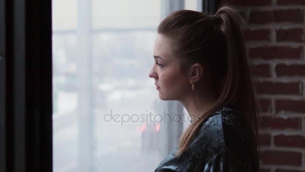 Üzgün kız pencereden dışarı bakar ve onun kafa döner - Video, Çekim