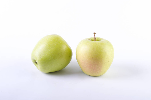 Fresh green apples on a white background. Two green apples on a white background. - Valokuva, kuva