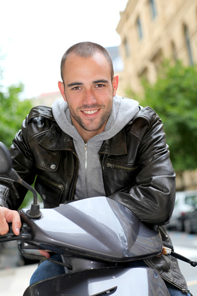 Portré fiatal férfi ült a motorkerékpár, a város - Fotó, kép