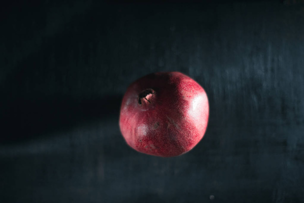 Fresh pomegranate on a black blurred background. - Fotografie, Obrázek