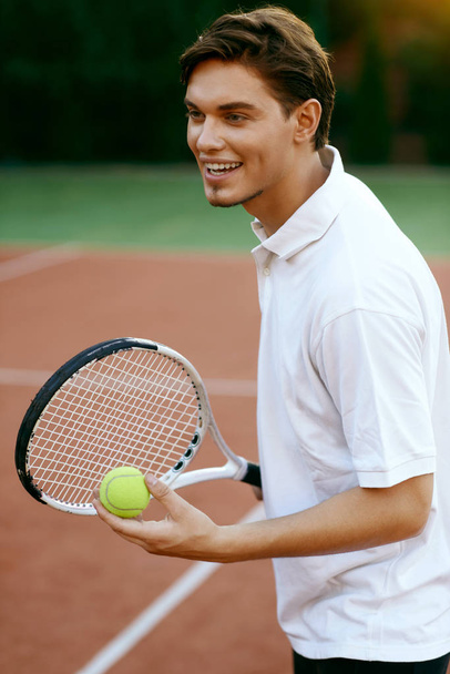 Man Playing Tennis Outdoors. - 写真・画像