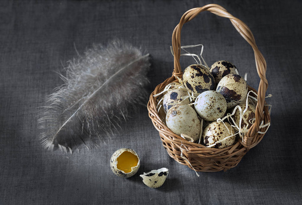 Still life with quail eggs in a wicker basket. - Foto, afbeelding