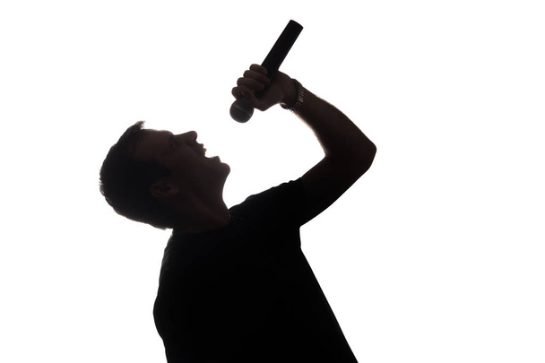 Молодий чоловік співає в мікрофон
 - Фото, зображення