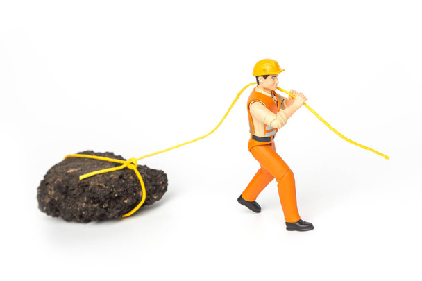 Miniature toy worker pulling a rope rock - Photo, Image