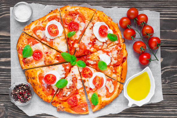 нарезанная домашняя пицца Маргарита с помидорами, базиликом, розмарином и сыром моцарелла
 - Фото, изображение