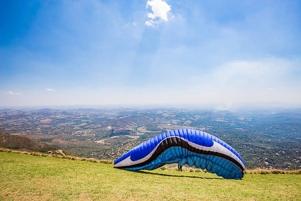 Belo Horizonte, Minas Gerais, Brazil. Paraglider starting a flight from top of the world mountain - Photo, Image