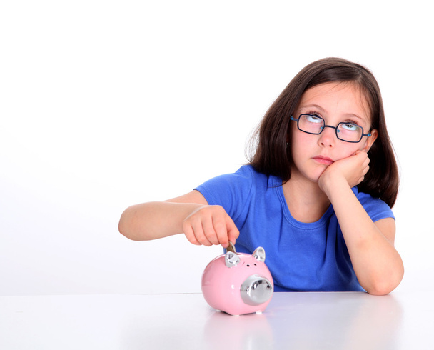 Little girl putting coin in piggybank - Zdjęcie, obraz