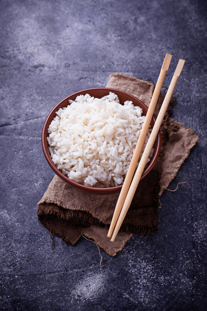 Bowl of boiled rice and chopsticks. Top view - Photo, Image